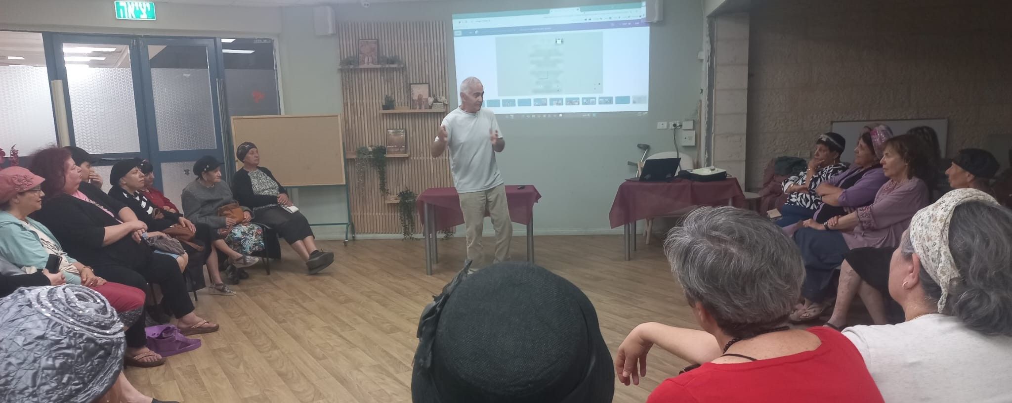 פיני לוי מרצה במועדון, הקהל יושב במעגל
